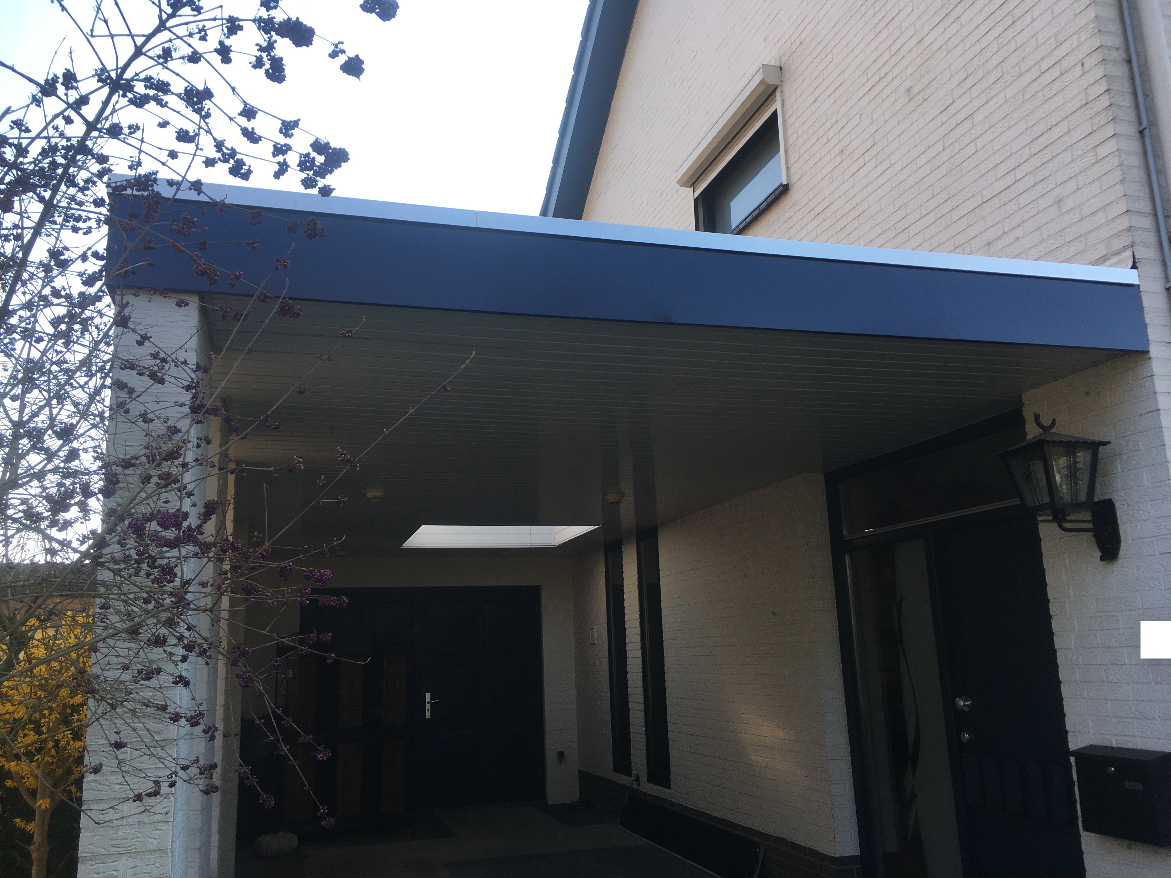 Na: carport volledig gerenoveerd met vernieuwde daktrimmen, boeiboordafwerking en andere detaillering, met nieuw binnenplafond